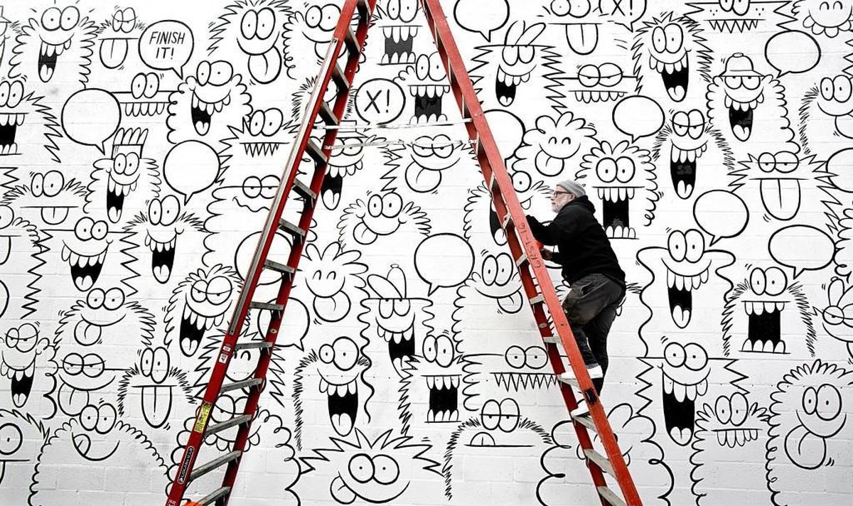 Graphic artist Kevin Lyons, in partnership with the Truth campaign and Vans shoes, put the finishing touches on a mural on the side of the Morgan West building, home to Trophy Brewing, on Thursday, December 3, 2015. Tobacco-free messages are worked into the painting. With about 100 of his signature monster faces, the 15’x40’ mural on brick took 2.5 days to complete. Inspired by his 2 daughters, Lyons used to leave his now signature faces as fun surprises in their school lunches.