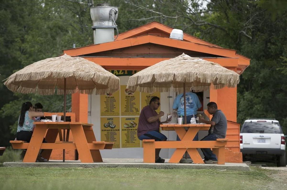 Customers enjoy lunch at shaded picnic tables on Tuesday, July 18, 2017 at Crazy Tacos on S. 5th Avenue in Smithfield, N.C.