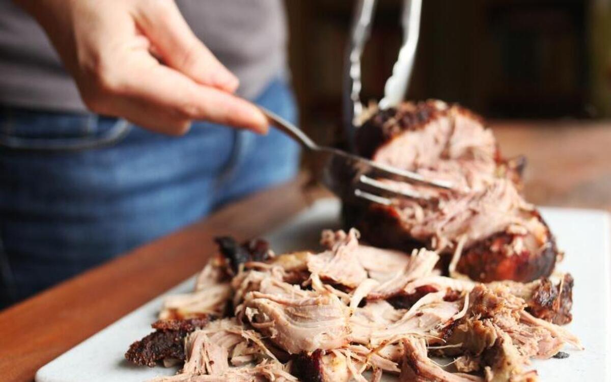 
Use a fork and tongs to pull apart the meat from the pork shoulder for Raleigh cookbook author and Weekend Gourmet columnist Fred Thompson’s recipe for Ultimate Smoked Pork Shoulder.
