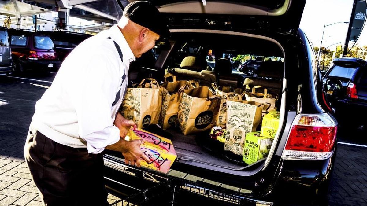 A driver for Uber loading a customer’s groceries into his car at a Whole Foods store in New York in 2015.