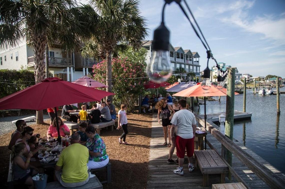 Patrons enjoy seafood from dockside tables overlooking the Intracoastal Waterway at Sears Landing Grill & Boat in Surf City.