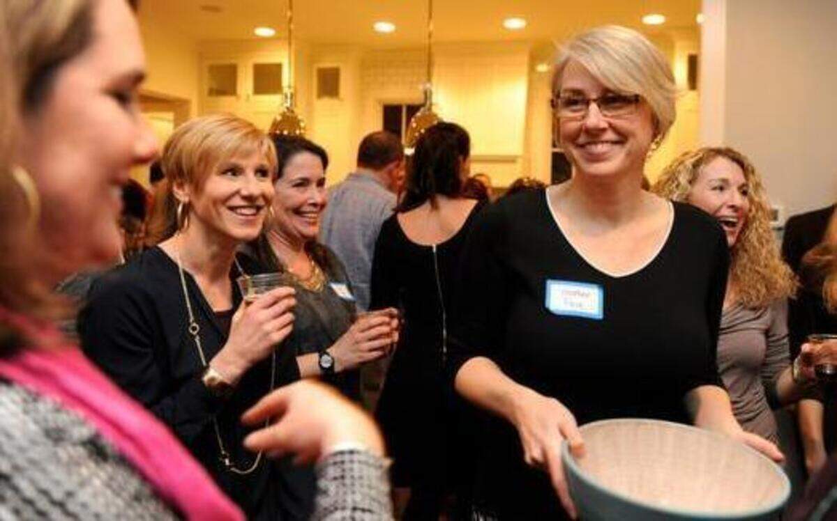 
Kristen Sloop, left, and Heather Pace, middle, enjoy the annual dinner March 7. “This neighborhood really loves to cook,” says Sloop. 
