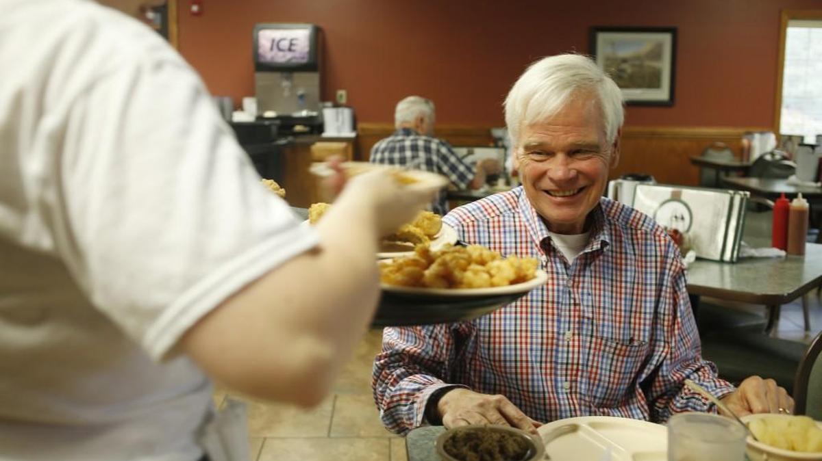 D.G. Martin, right, receives his lunch order from waitress Ashley Earp, left, at Holt Lake Bar-B-Q & Seafood in Smithfield on Sept. 20, 2016. Martin has included the restaurant in his newest book, “North Carolina’s Roadside Eateries.”