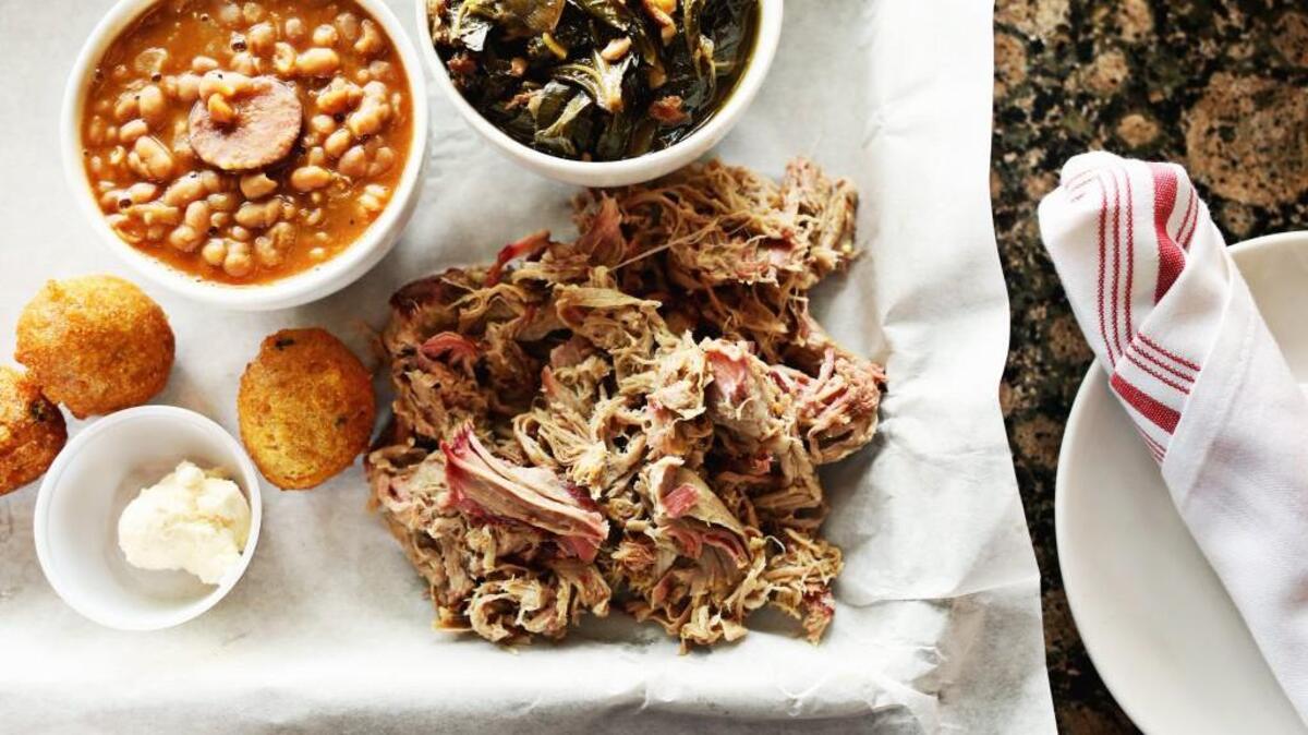 Meat-and-threes emulate the serving style of old-time Southern home cooks. Here at CrossTies Barbecue in Carrboro, the Pulled Pork is served here with a side of hush puppies, bourbon smoked baked beans, and collards.