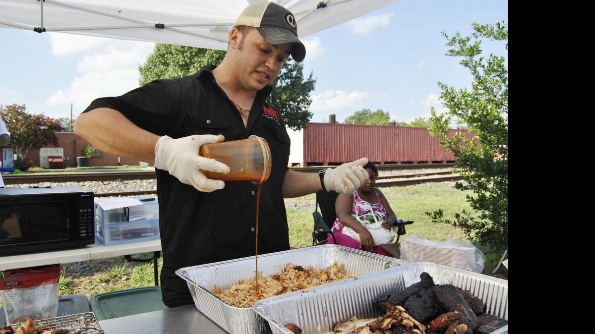 
Christopher Prieto pours sauce on shredded chicken barbecue at the cook-off in Wendell and won first place. He plans on opening a restaurant in Wendell later this year.

