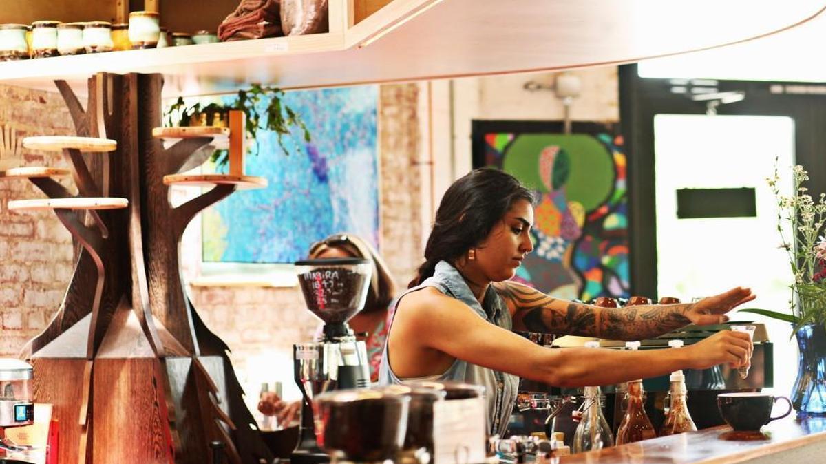 Barista Esar Aadil prepares a beverage at the coffee bar at the new Cocoa Cinnamon on Hillsborough Road in Durham on Wednesday, June 1, 2016. The intricate mahogany and wenge bartop was designed by Art Knowles of Word of Mouth Carpentry. He also made the tree (far left) which goes through the upper cabinet and up to the rafters; it is meant to echo the Lacebark elm in the outside courtyard.