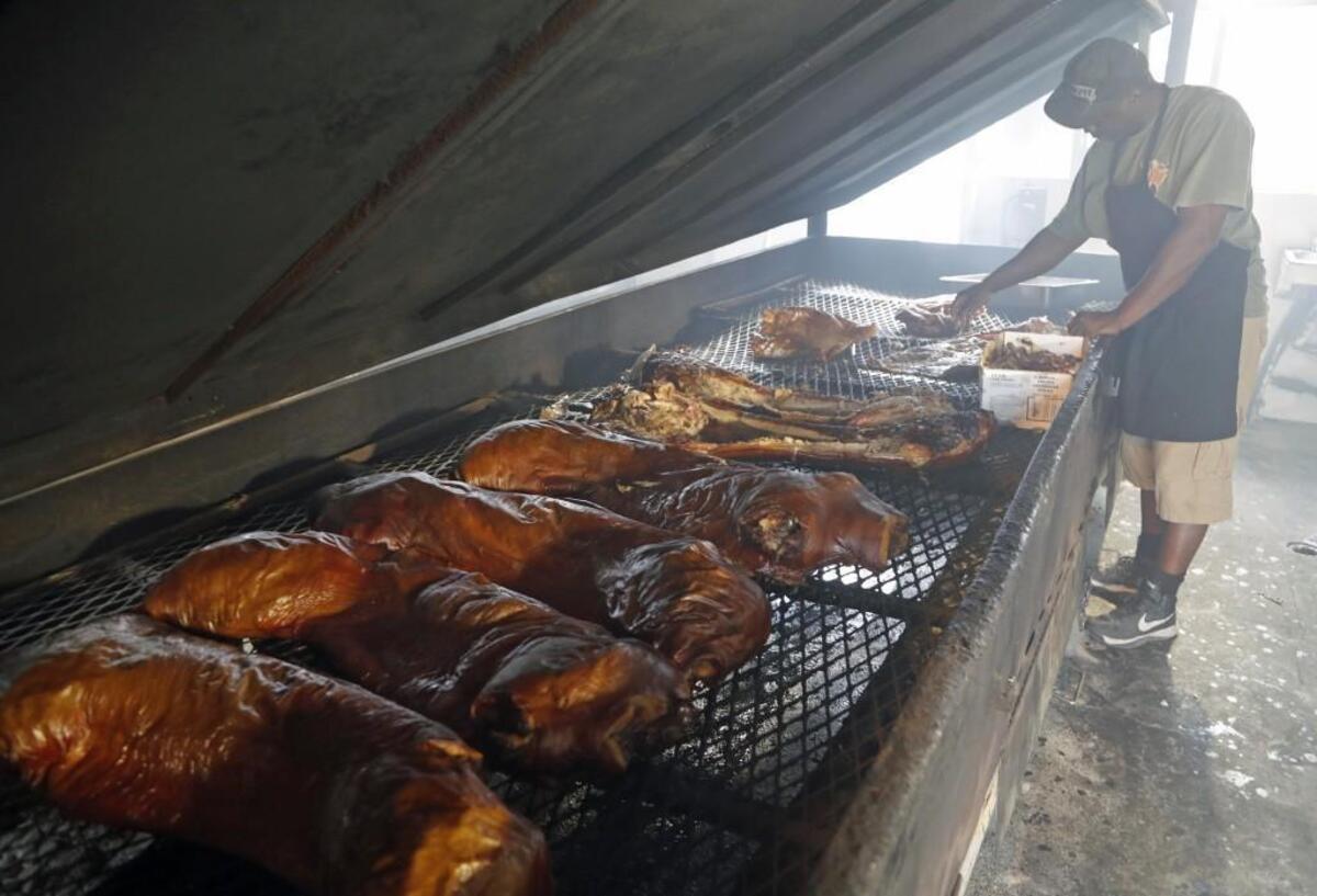 Arthur House pulls the pork from the cooker to be taken inside and chopped up at B’s Barbecue in Greenville NC, on June 7, 2017. B’s is an old-time barbecue restaurant that ranks near the best in the state in several surveys.