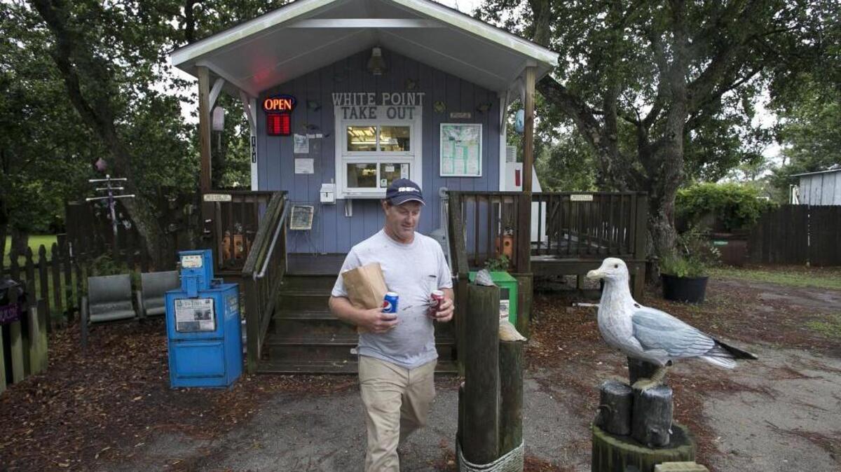 Jason Gillikin of Williston, N.C. picks up burgers for lunch at the White Point Take Out on Thursday, June 8, 2017 in Atlantic, N.C.