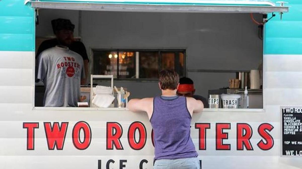 A customer buys ice cream from Two Roosters Ice Cream during a concert in downtown Raleigh on July 21, 2016. Two Roosters will soon have its first brick-and-mortar location after operating from a vintage camper attached to a truck.