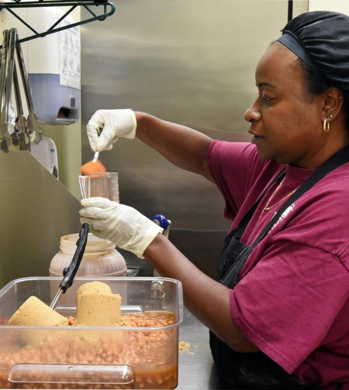 Frances Gould carefully measures out some cayenne pepper as she makes a batch of baked beans prior to the lunchtime rush at Pattan's Downtown Grille in Rockingham, N.C., Thursday, May 25, 2017.