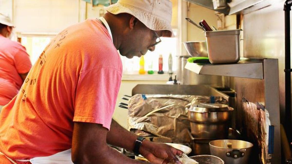 Durham chef Ricky Moore, owner of the Saltbox Seafood Joint in Durham, prepares orders during lunch on April 27, 2016. Moore offers a Strawberry Hibiscus “Espanhola” Cocktail for Juneteenth.