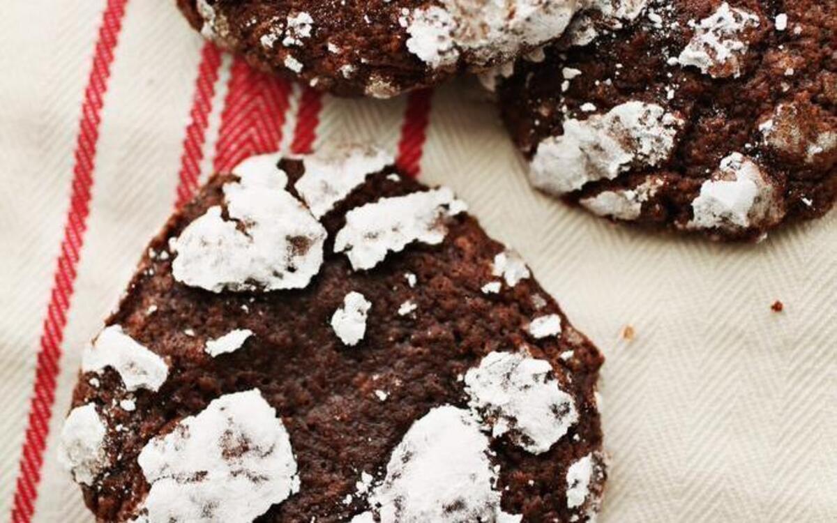 Fresh Snow on Plowed Ground Cookies are made with a thick, sticky dark chocolate batter and sprinkled with powdered sugar, the cookie plumps up to look like a perfect circle of plowed ground dusted with a trace of snow.