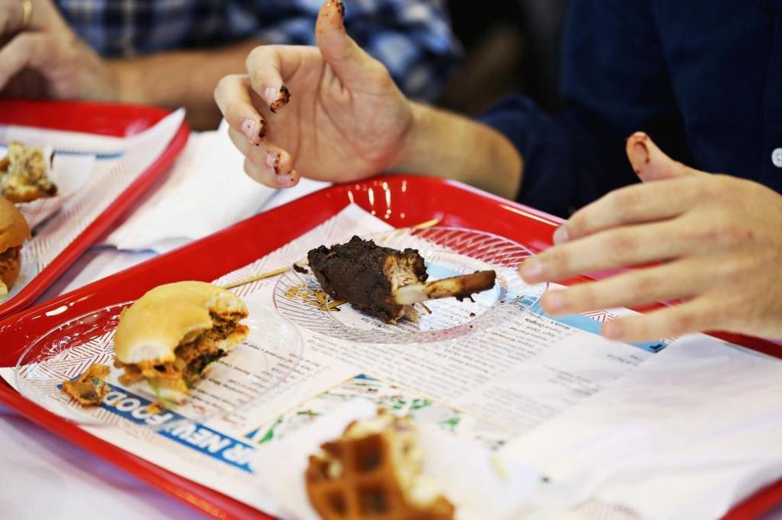 News & Observer food writer Drew Jackson's fingers are coated in sauce after trying the Barbecue Jerk Ribs from Cool Runnings Jamaican during the N.C. State Fair Media Lunch Monday, Oct. 9. 2017.