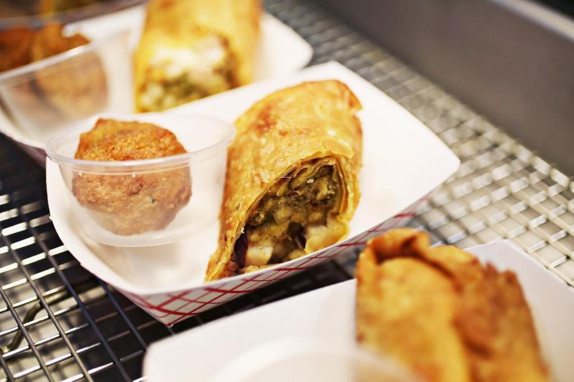 The Thanksgiving Egg Roll is served with a side of Bacon Cheese Collard Bites from Woody’s Wing Wagon.
