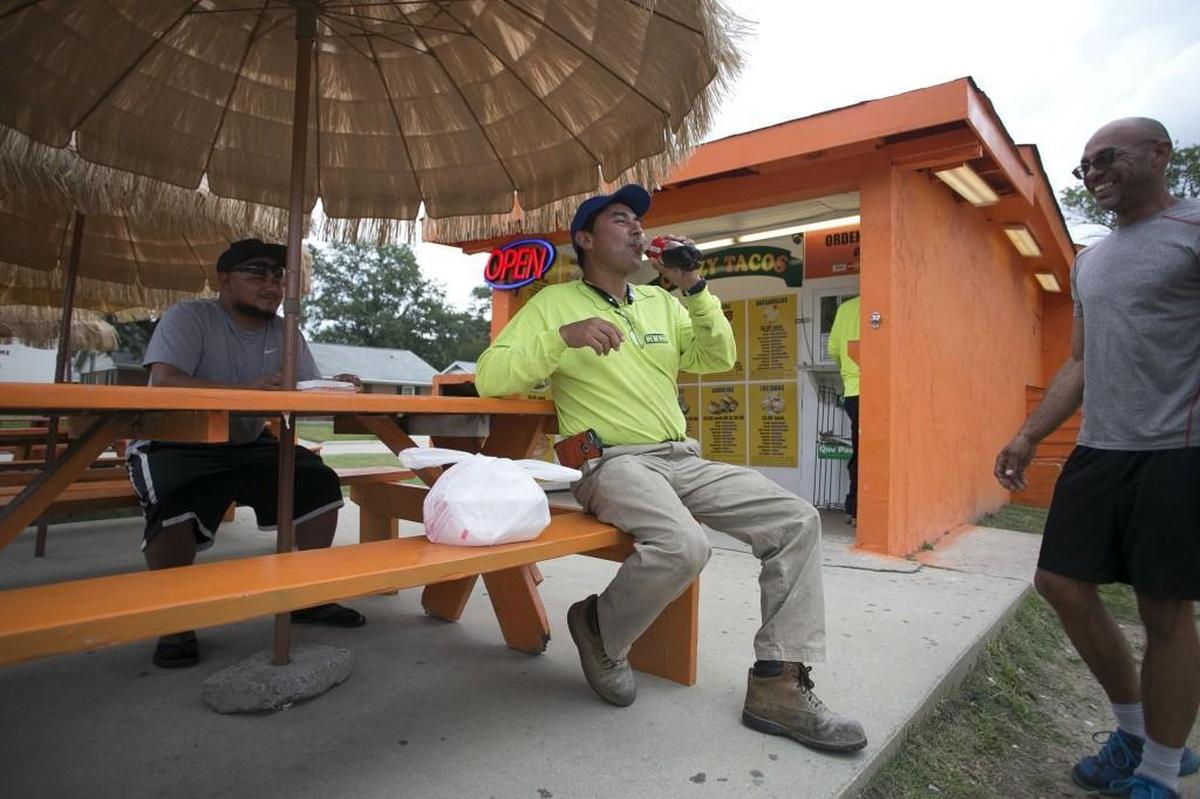 Juan Morales, center, along with Billy Cubero, right, wait for their food on Tuesday, July 18, 2017 at Crazy Tacos on S. 5th Avenue in Smithfield, N.C. The construction workers from Gainesville, Fla. stop regularly at Crazy Tacos as they travel to work along the east coast.