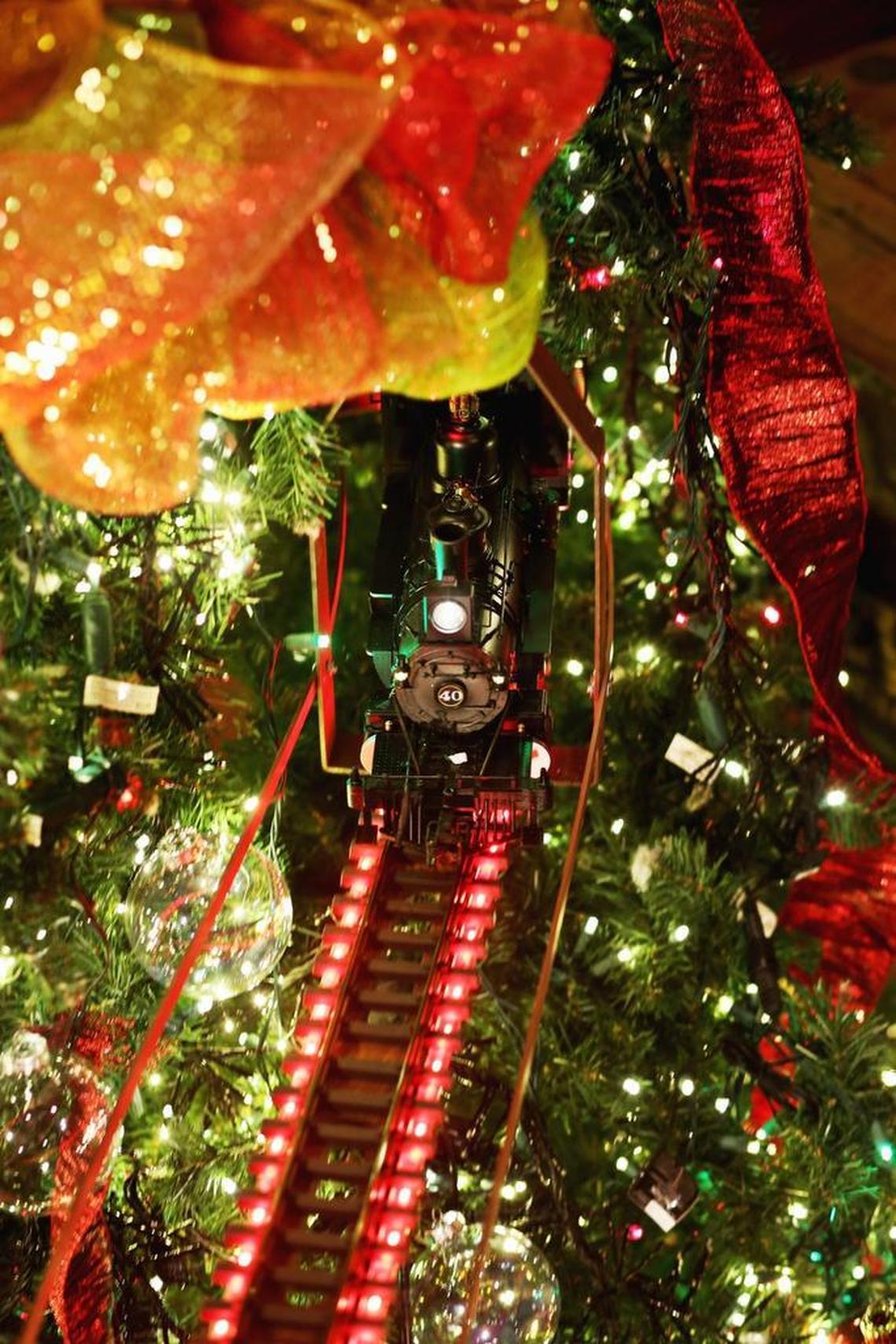 The toy train emerges from the giant Christmas tree in the gun room known as the “train tree” at Angus Barn in Raleigh on Wednesday, Nov. 23, 2016.