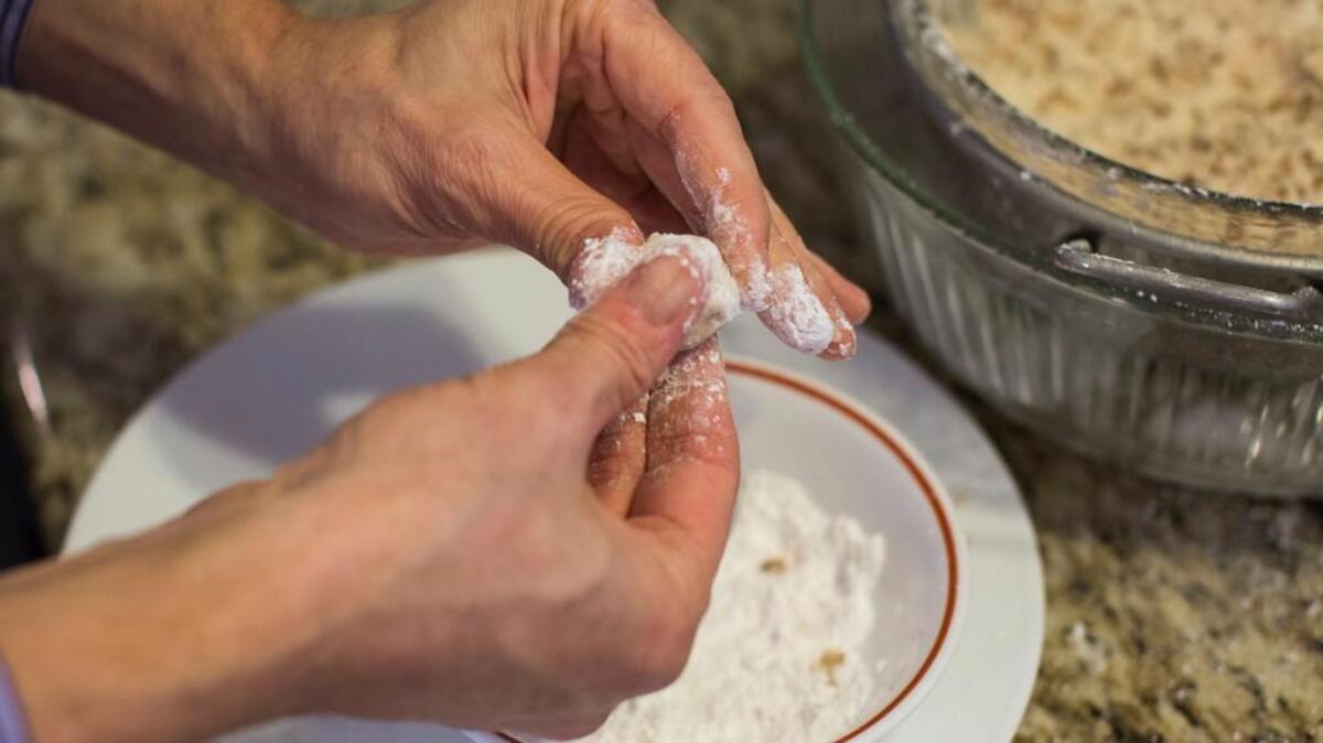 Steve Millward rolls a ball of dough, consisting of butter, powdered sugar, pecans, and Red Stag Black Cherry Bourbon, before it is dipped in melted chocolate and turns into Bourbon Balls, in his Raleigh, N.C. home on Sunday, November 22, 2015.
