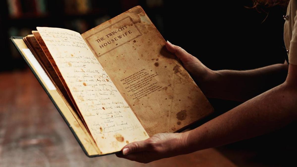 
Alison Barnett, Business Services Coordinator for the North Carolina Collection, holds the cookbook, "The Young Housewife's Counsellor and Friend," dating back to 1875 which inspired her to curate an exhibit of 900 cookbooks at UNC'S Wilson Library. The cookbook is the oldest included in the exhibit, " From Brunswick Stew to Barbecue: The Cookbook as Cultural History" which is on view from opens June 18 and will be on view through October 4. 
