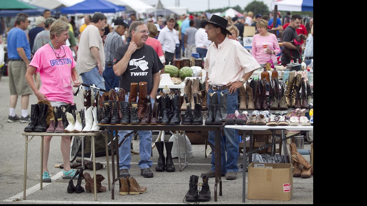 
Larry Denny, right, talks with customers in his space where he sell cowboys boots at the Raleigh Flea Market, which is held every weekend at the N.C. Fairgrounds.
