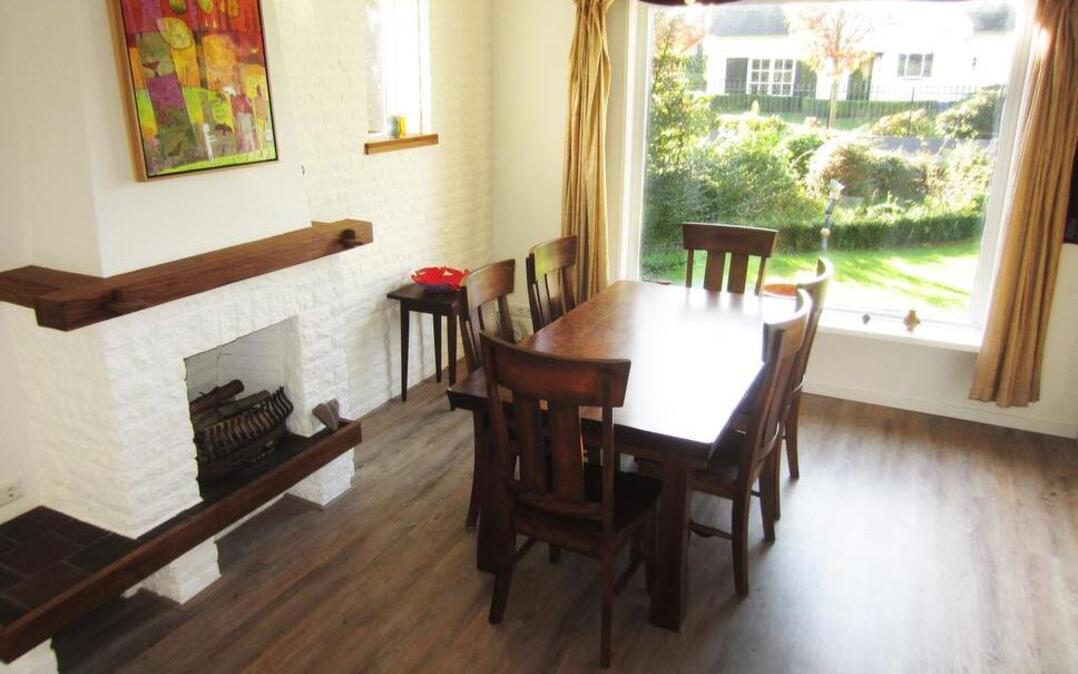 
 In Diane Daniels and Selina Kok’s house in the Netherlands, the living/dining area features a brick fireplace with a walnut mantel. The picture window is typical of Dutch houses. Their 1,100-square-foot house (below) is about 75 miles southeast of Amsterdam. 
