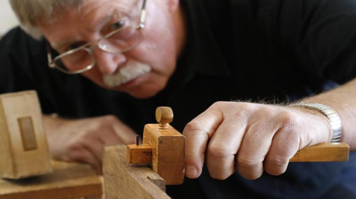 Woodworking student Danny Murray eyes a handmade woodworking gauge while he marks out his saw cuts on his slab of walnut board Saturday, February 27, 2016 while participating in a bookstand making woodworking class at Roy Underhill's Woodwright School in Pittsboro, NC.