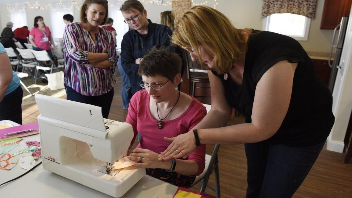 Hillary Griffin, center, learns to sew a standard quilt block called "orange peels" from Valerie Luberecki during a meeting of the Modern Quilt Guild in Raleigh.