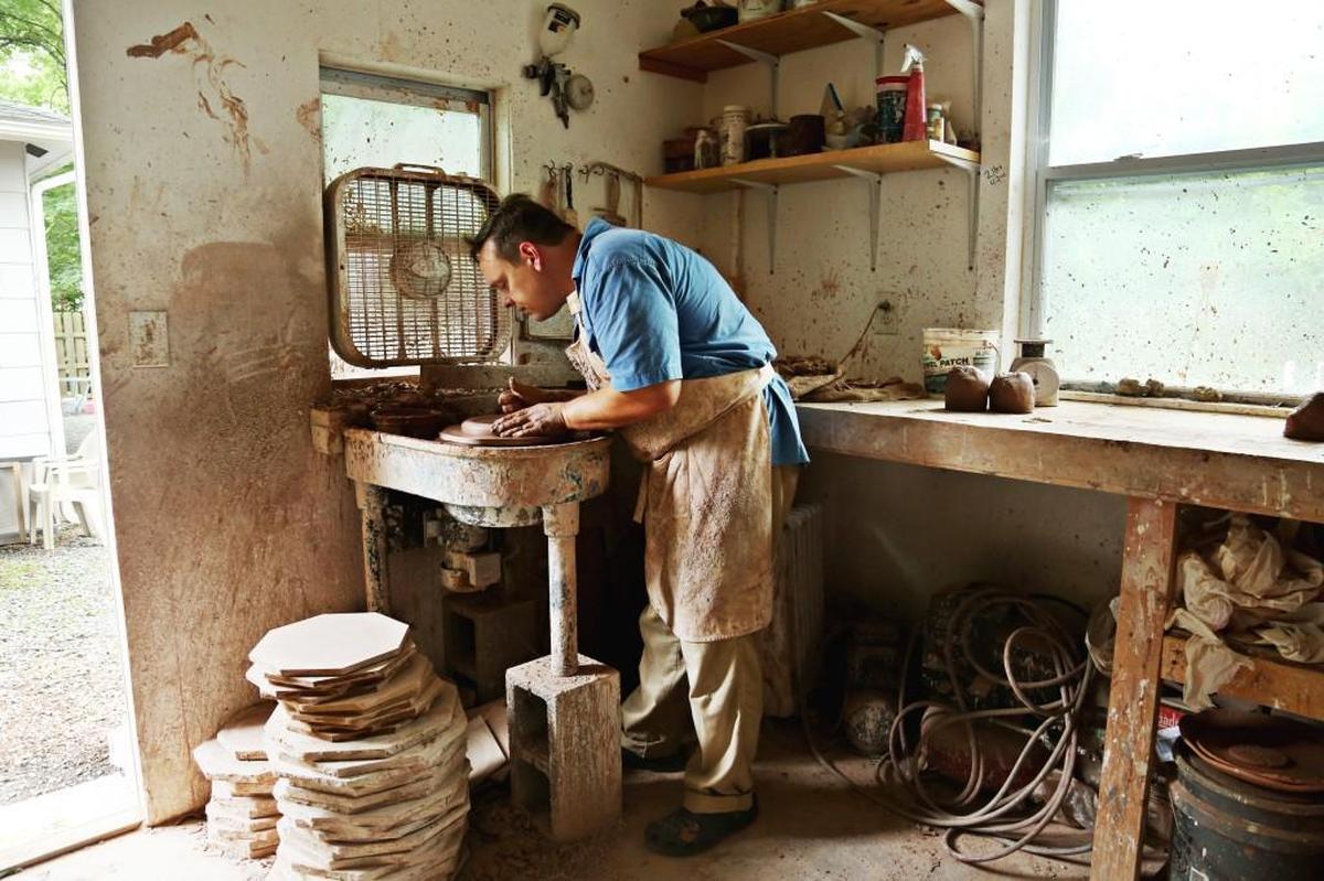 Durham potter Matt Hallyburton shapes a dinnerware piece on the wheel for an order at his home studio on June 20, 2017.