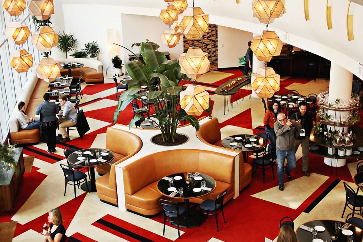 The Durham’s dining room is an airy, casually inviting space whose vibrant mid-century modern decor takes its cues from the former Home Savings Bank building, an iconic 1968 structure that has been restored.