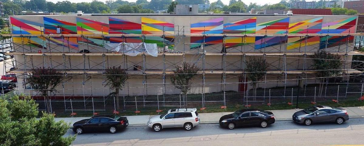 A new installation art piece on the side of the downtown branch of the Durham YMCA nears completion Friday, Sept.4, 2015. As part of Nasher10, a celebration of the first decade and beyond, Duke's Nasher Museum commissioned two large-scale murals by abstract painter Odili Donald Odita . Odita was born in 1966 in Enugu, Nigeria, and lives and works in Philadelphia. His abstract paintings explore ways to trigger memory and address the human condition through color, pattern and design.