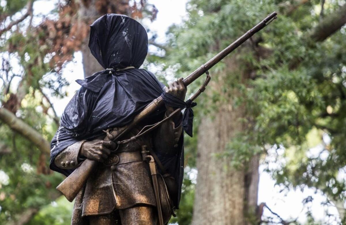 The Silent Sam statue, a memorial to Confederate soldiers, on the University of North Carolina’s Chapel Hill campus was covered in black cloth as few hundred demonstrators gathered at the statue Sunday, August 13, 2017 after violent clashes between white supremacists and counter protesters in Charlottesville, Va. turned deadly.