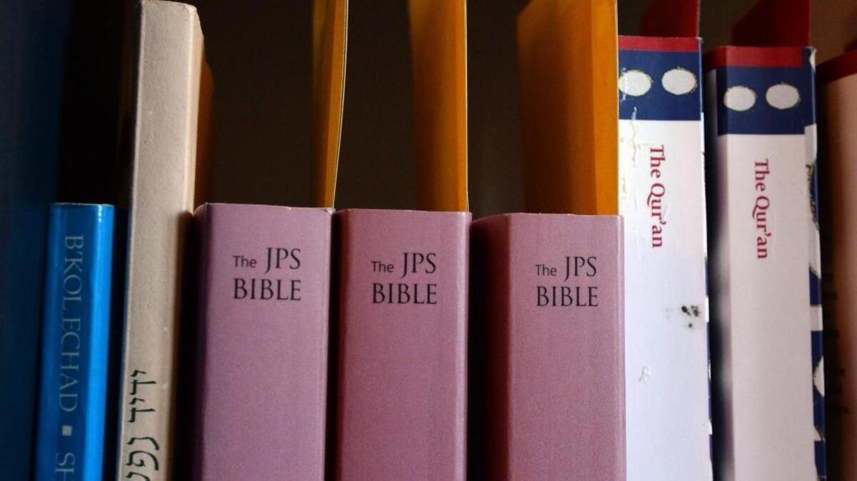 Copies of the Jewish Bible and The Qur'an sit next to each other on a bookshelf, Thursday, February 18, 2016.