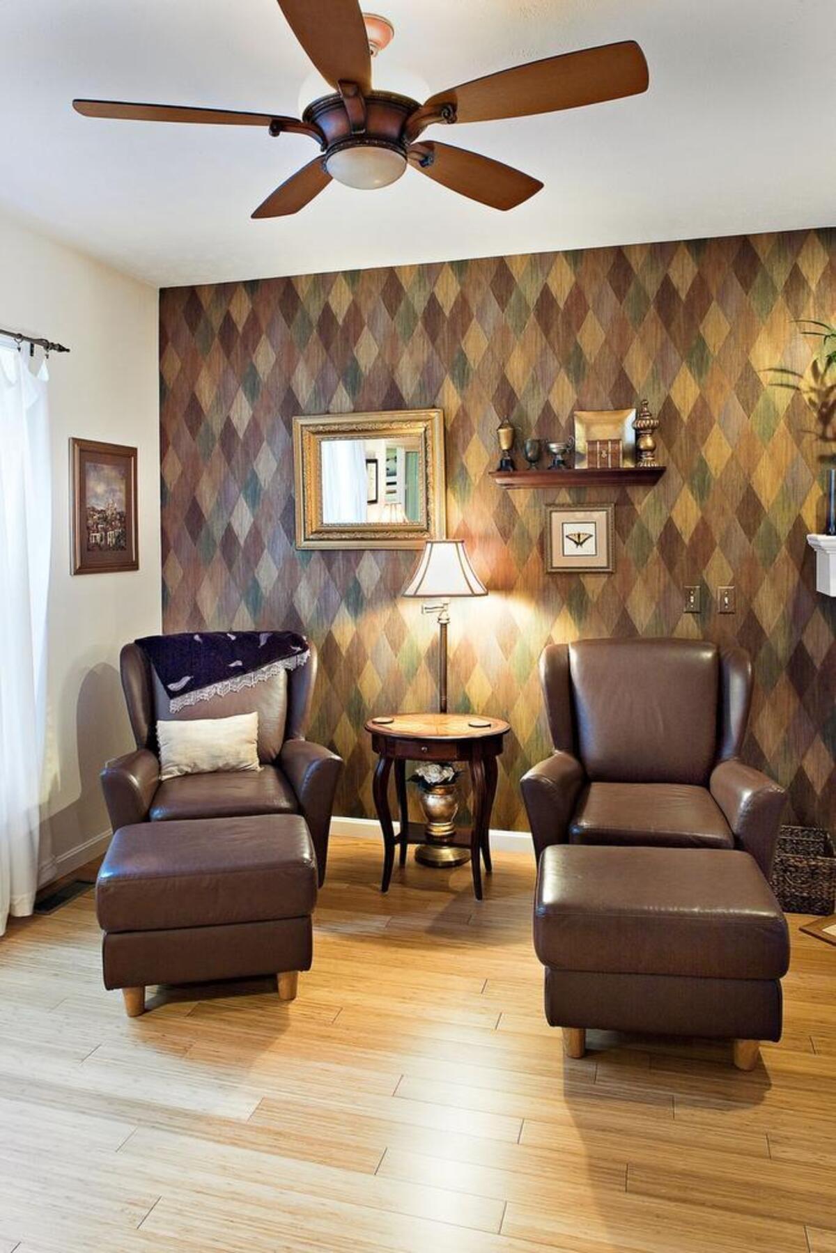Using monochromatic furnishings against a colorful accent wall can further increase its visual impact. This seating area has harlequin metallic brushed wallpaper.