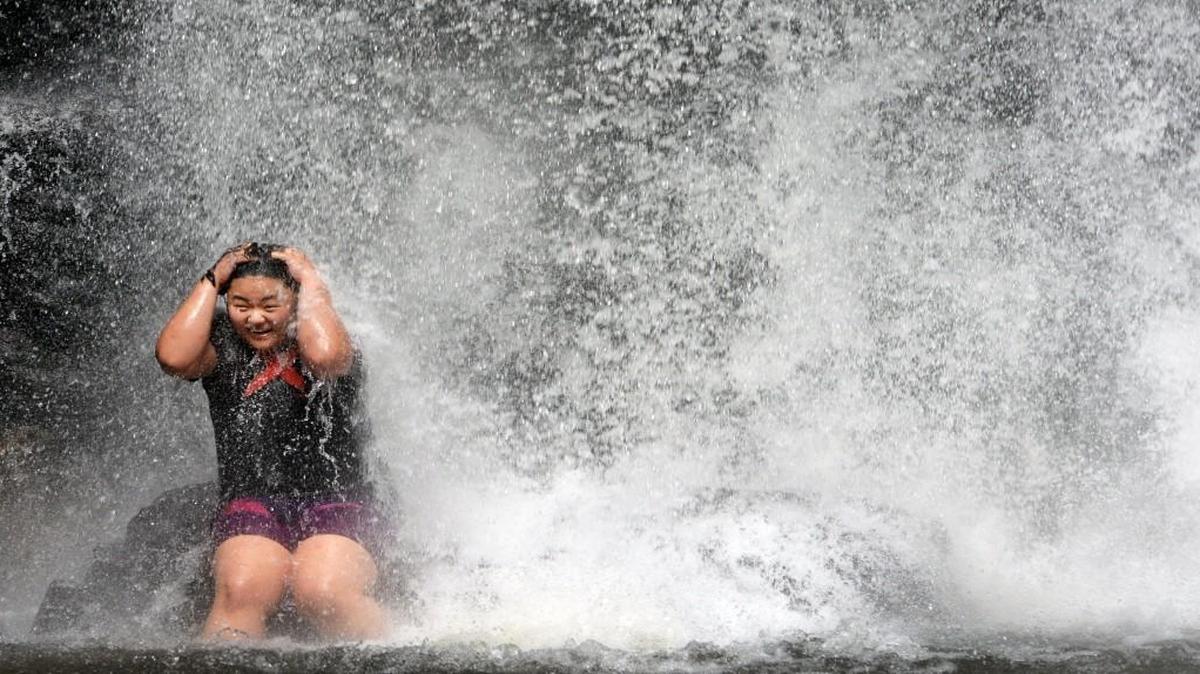 T.K. Lee, of Augusta, Ga., enjoys the chilling waters of Looking Glass Falls in the Pisgah National Forest last summer.