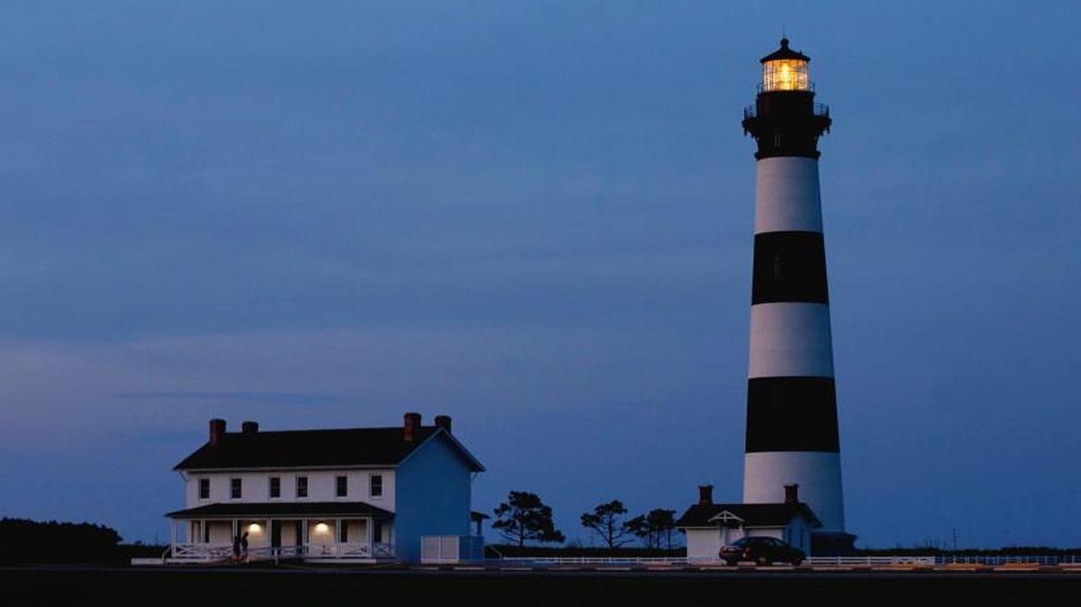 The Bode Island Lighthouse is illuminated as dusk falls on the Cape Hatteras National Seashore on the Outer Banks.