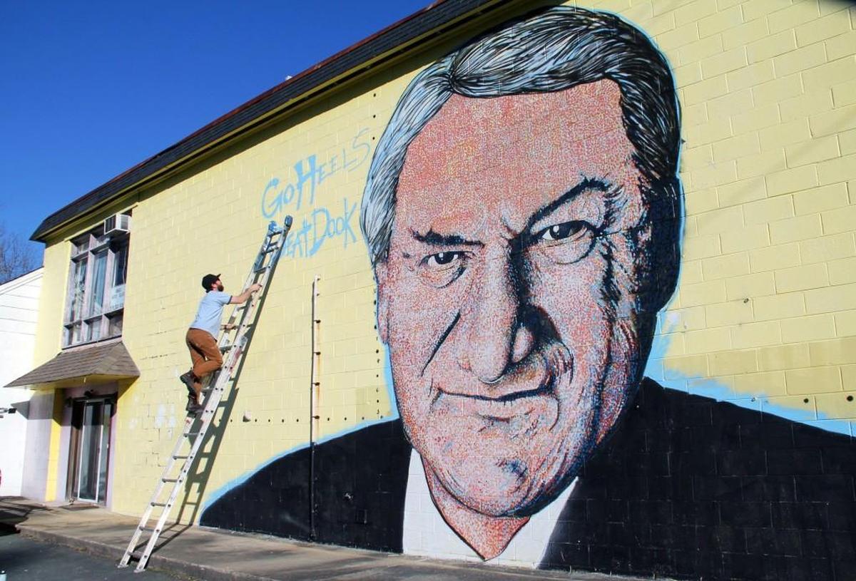 Painter Scott Nurkin works on a larger-than-life mural of UNC coach Dean Smith on a building at Smith Level Road and U.S. 15-501 on the Orange-Chatham county line Saturday, March 7, 2015.