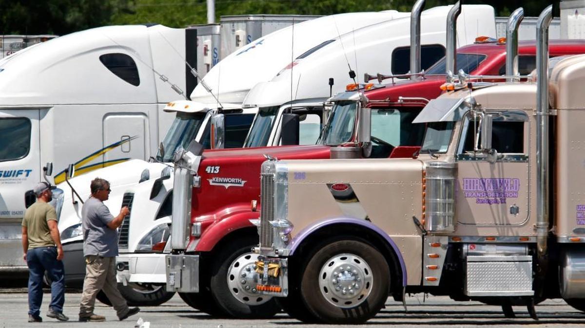 Drivers approach their semi-truck while parked in a rest area of the Truckstops of America Travel Center at the Highway 61 exit in Guilford County, NC, on June 5, 2015. This popular truck stop is on the busy I-40/85 interstate corridor through North Carolina.