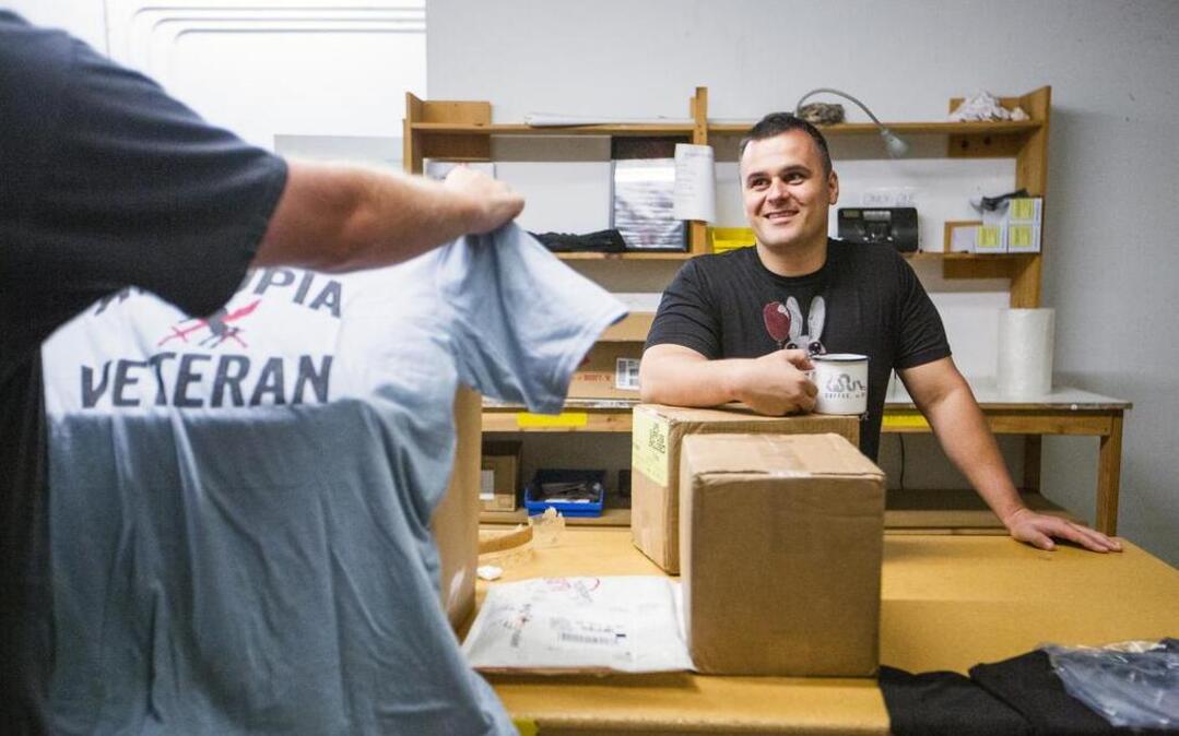 Nick Palmisciano, owner of Ranger Up, a Durham-based military and MMA apparel company, looks at a new shipment of T-shirts.