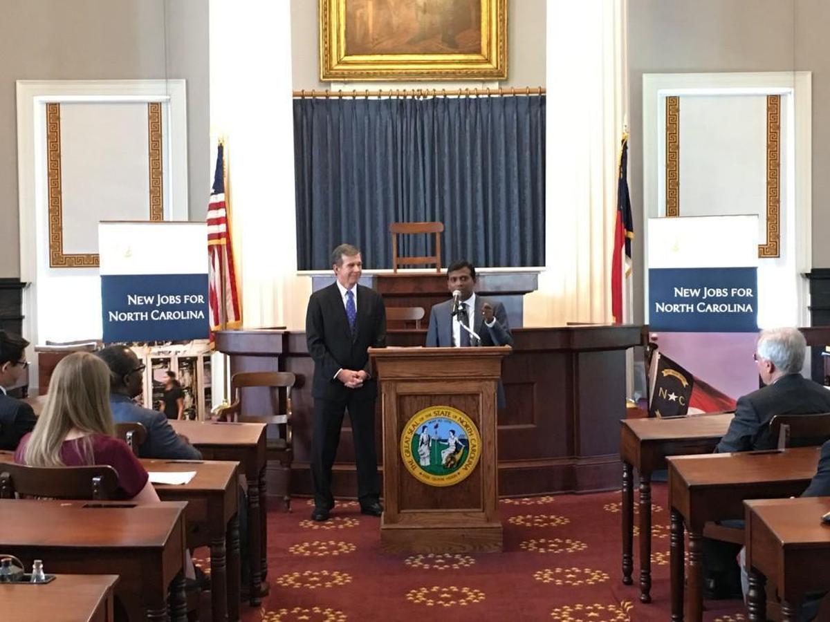 Gov. Roy Cooper with Infosys president Ravi Kumar announcing that the tech company will bring a facility to the Triangle with 2,000 jobs. The ceremony was in the House chambers of the Capitol.