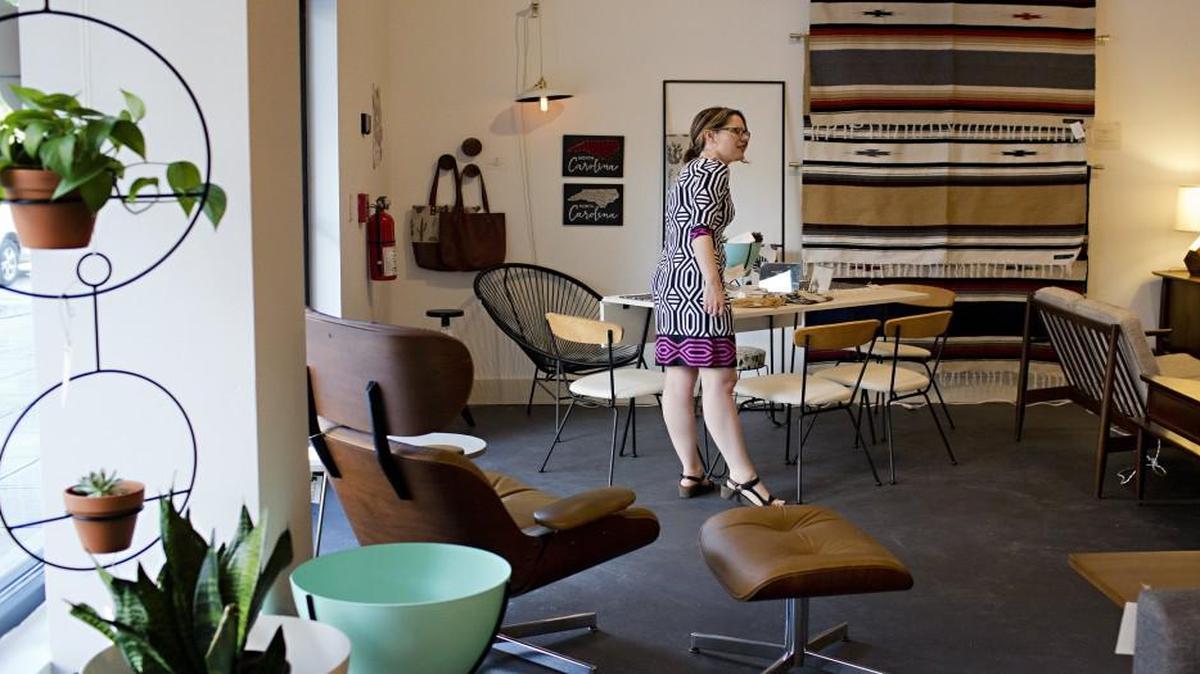 Kelly Wohlgenant, owner of Retro Modern Furnishings on the ground floor of Hue Urban Apartments, prepares her downtown store for a grand opening party Friday, April 29, 2016 in Raleigh.