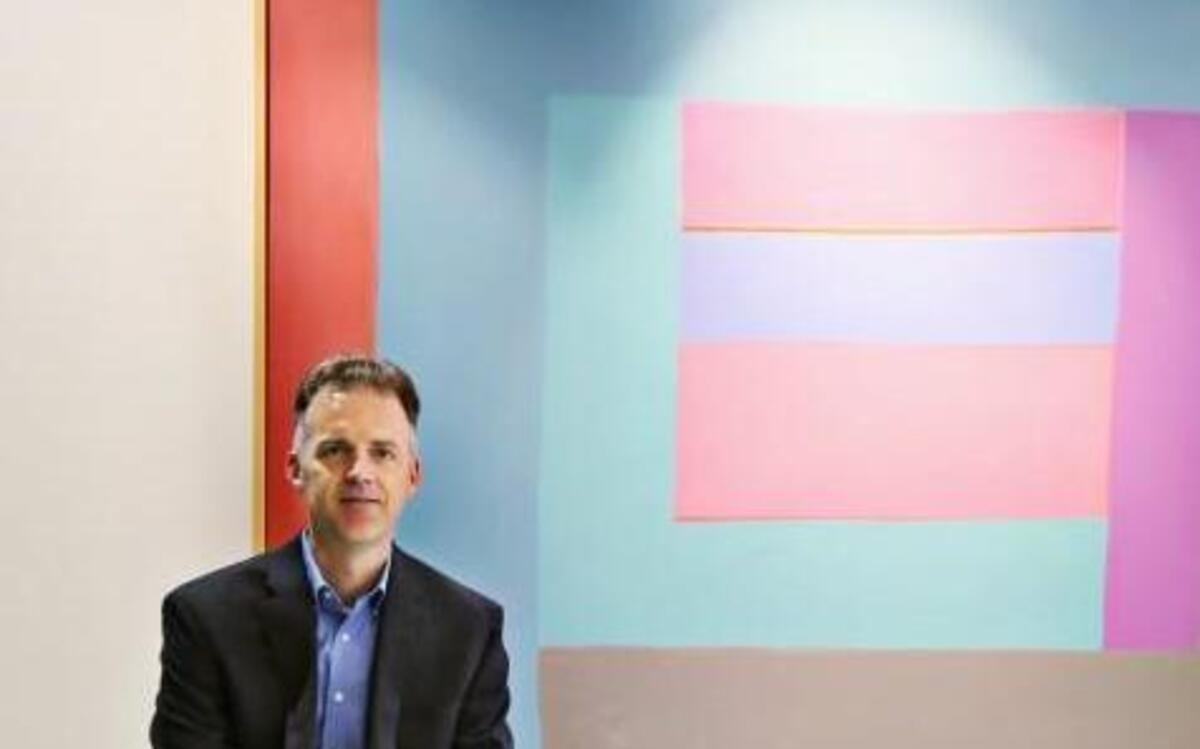 Charles Coble of Brooks Pierce law firm sits in front of one of his favorite pieces, “Simmer” by George Bireline, in the art collection at the firm’s downtown Raleigh office.
