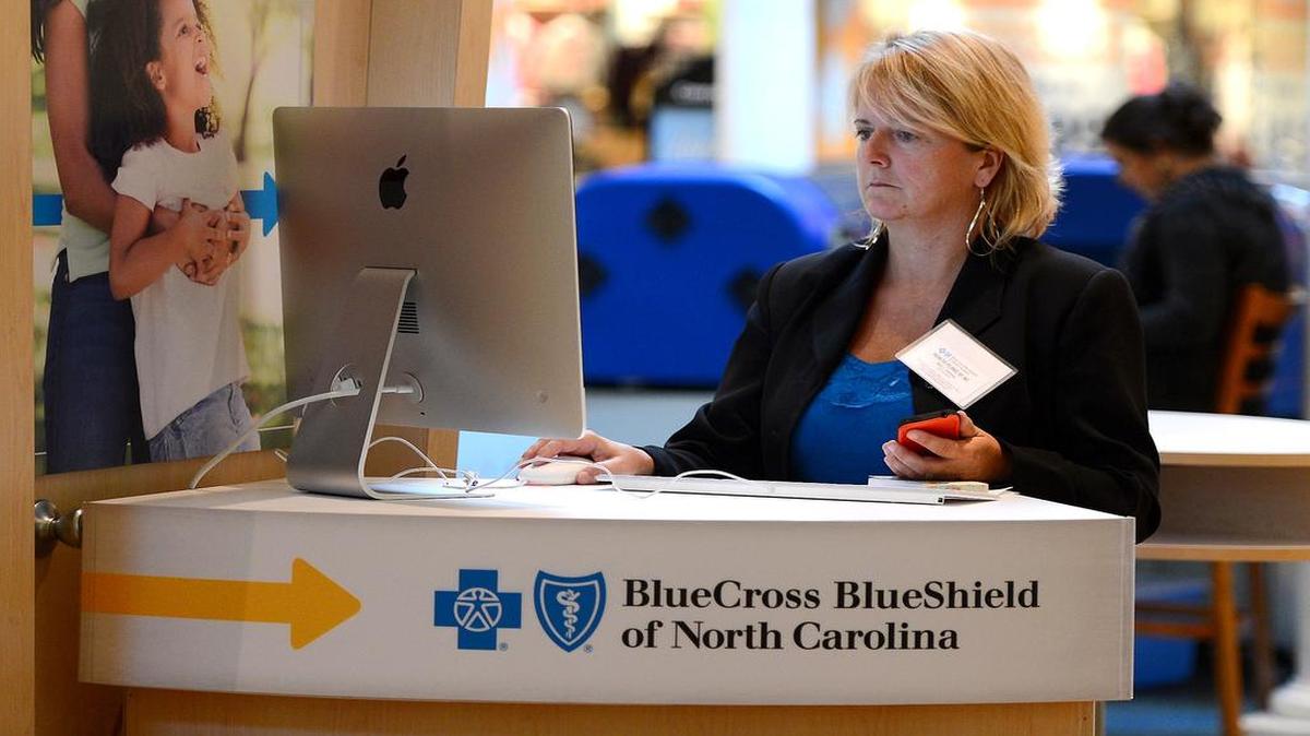 
Kelli Tremblay, an authorized agent with BlueCross BlueShield of North Carolina, works a station at Concord Mills on the first day of enrollment for the Affordable Care Act in 2013. 
