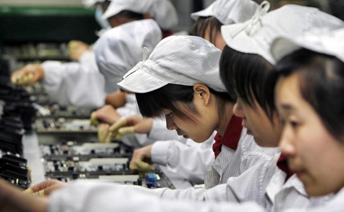 A file photo shows workers on the production line at the Foxconn complex in Shenzhen, China. Foxconn makes Apple's iPhones among other electronics items.
