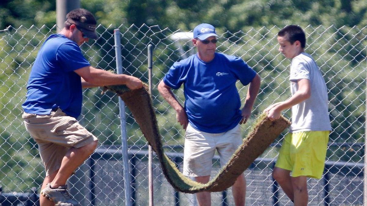
Raleigh Parks and Recreation sod-renovation crew supervisor Jeff Bryant, center, oversees the placement of strips of fresh rolled sod on June 17, 2015, by a Raleigh Parks and Recreation Department employee and a teen from the Raleigh Summer Youth Employment Program, right.The half-acre multipurpose field at Chavis was closed to public use for the sod renovation project earlier in June and will reopen Aug. 1, according to Bryant.
