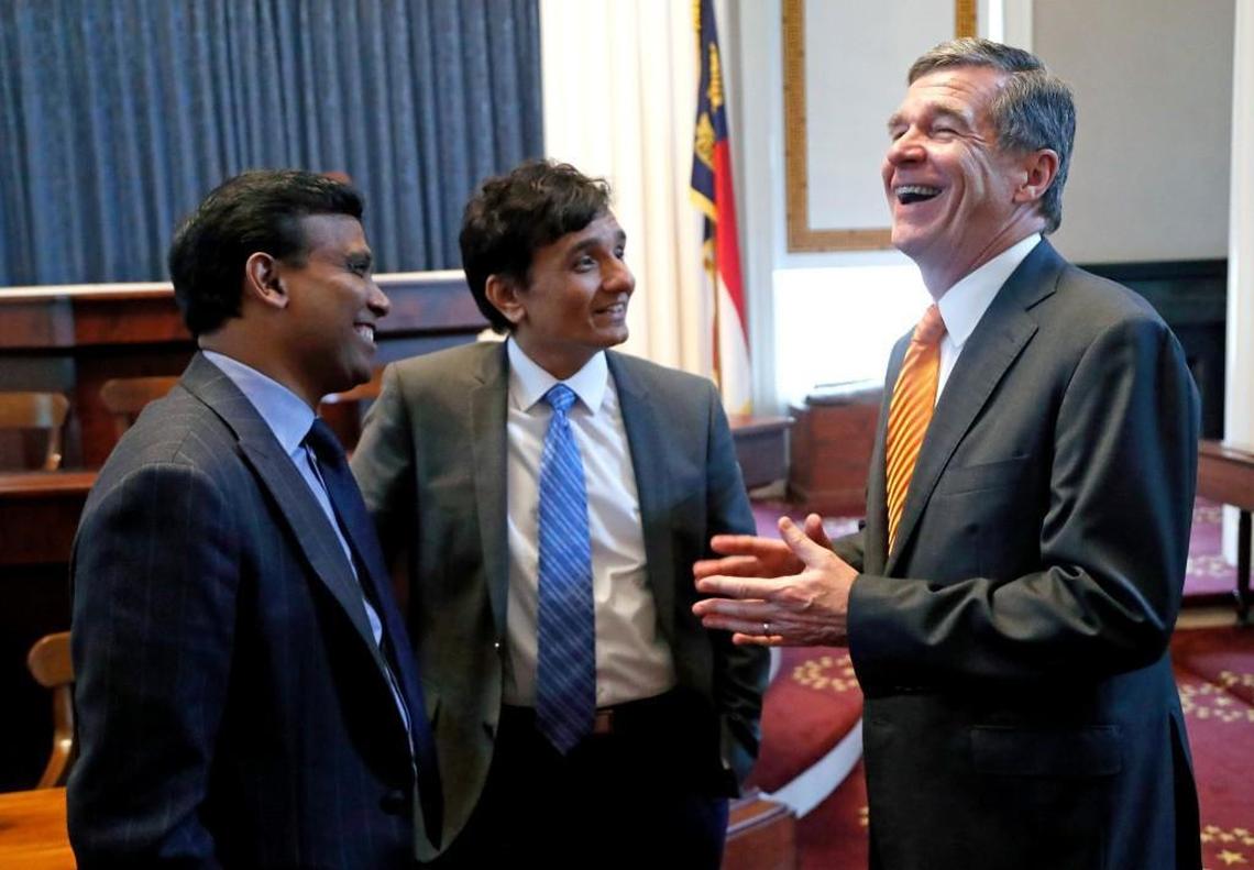 Infosys deputy COO Ravi Kumar, left, Infosys executive VP and CFO Ranganath Mavinakere, center, and N.C. Gov. Roy Cooper enjoy a laugh together at the conclusion of the event where they announced that the tech company would locate a new facility near Brier Creek in the RTP. The press conference was held in the old House chambers in the Capitol Building in Raleigh on Sept. 12, 2017, The company is expecting to bring about 2000 jobs to the area.