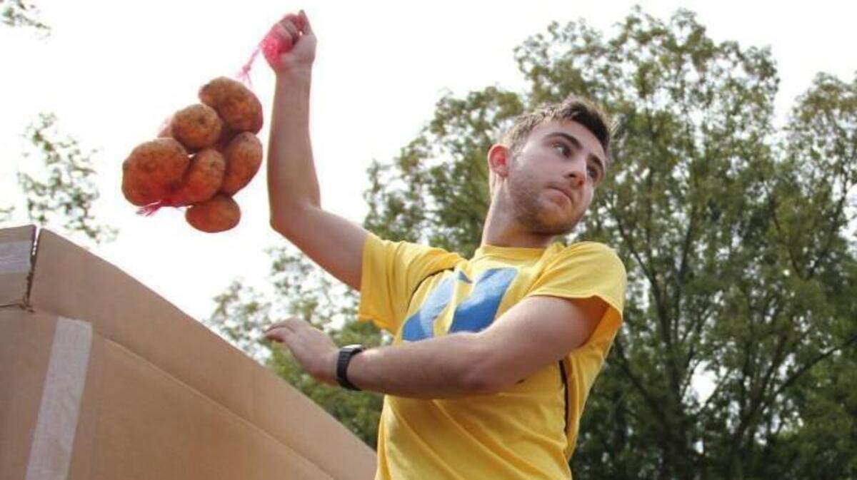 Duke freshman Tomas Cabo-Hervada, 17, of the Bronx, N.Y., lifts a bag of potatoes at the "potato drop" at Smith Warehouse on Buchanan Boulevard in August 2015. The bagged potatoes went to groups such as Durham Rescue Mission, Urban Ministries of Durham and the Food Bank of Central & Eastern North Carolina.