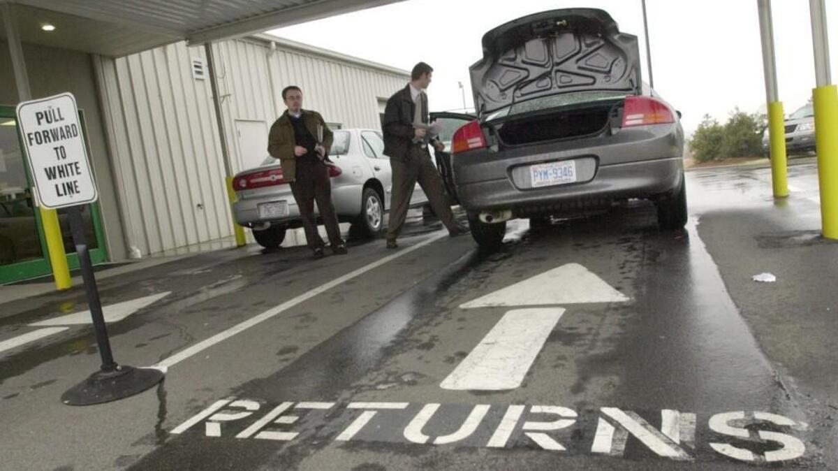 In this file photo, business traveller Brian Jackson, left, from Nashville, Tenn., drops off his rental car at the Enterprise Rent-A-Car lot at Raleigh-Durham International Airport while Enterprise employee Ryan Thistlethwaite checks the car over.