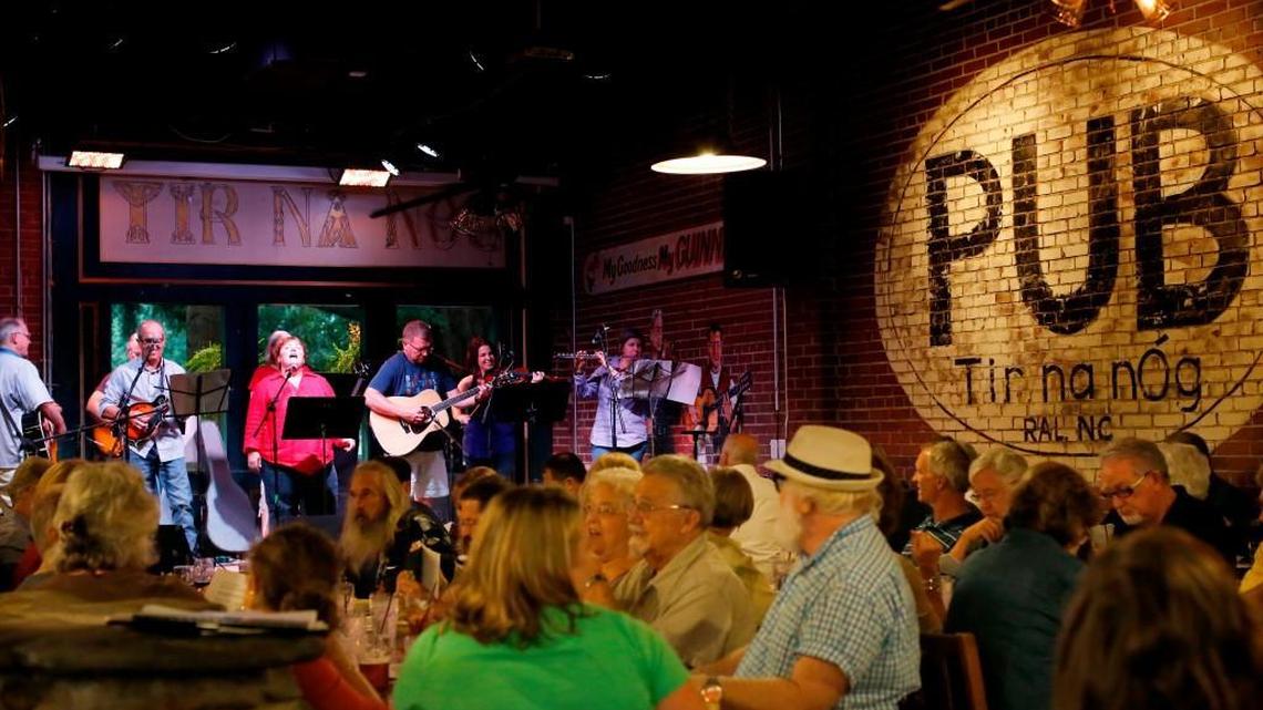Worship leaders sing on stage during a monthly beer and hymns gathering at the old Tir na nOg location on Blount Street on Sunday, September 7, 2014.