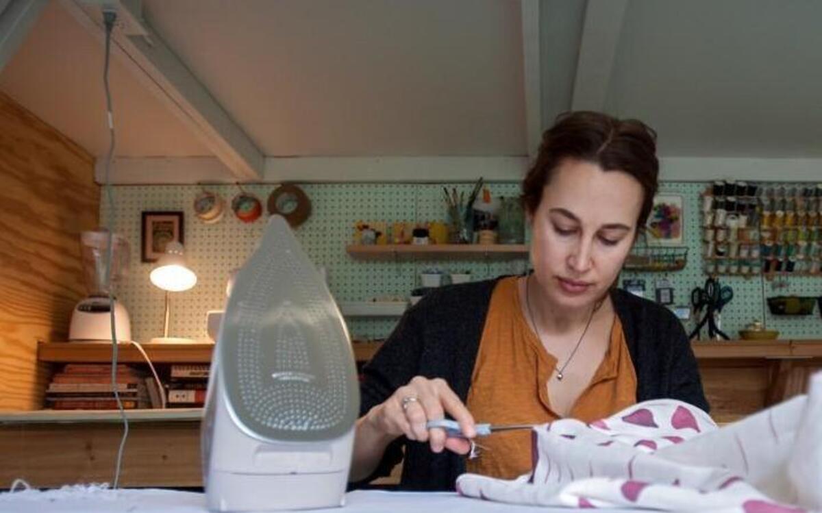 Durham textile and surface design artist Brooke Heuts puts the finishing touches on pillowcases while working in her studio. Heuts will have a pop-up shop at Light Art + Design gallery on Saturday in Chapel Hill.