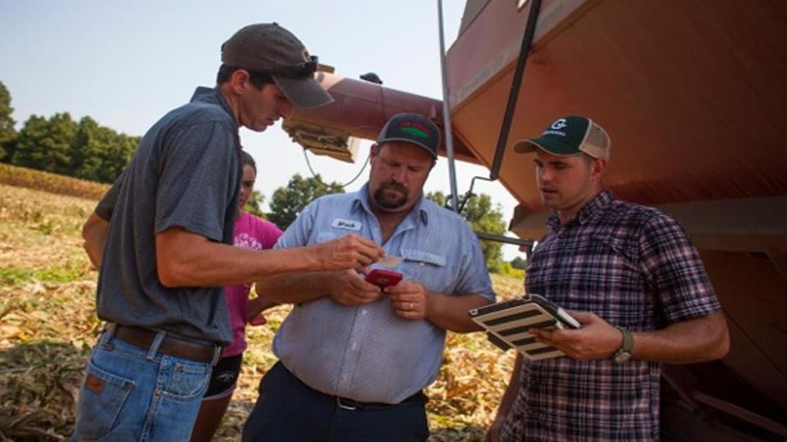 From left, Growers CEO Steven Valencsin, farmers Taylor Roberts and Mark Roberts, and Growers employee John Montgomery review data collected by the Raleigh company.