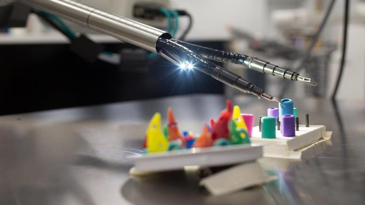 Katy Fitzgerald moves pegs using SurgiBot, a surgical robot designed by TransEnterix in 2016.